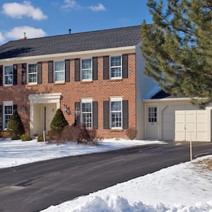 Red brick home with heated driveway in the winter